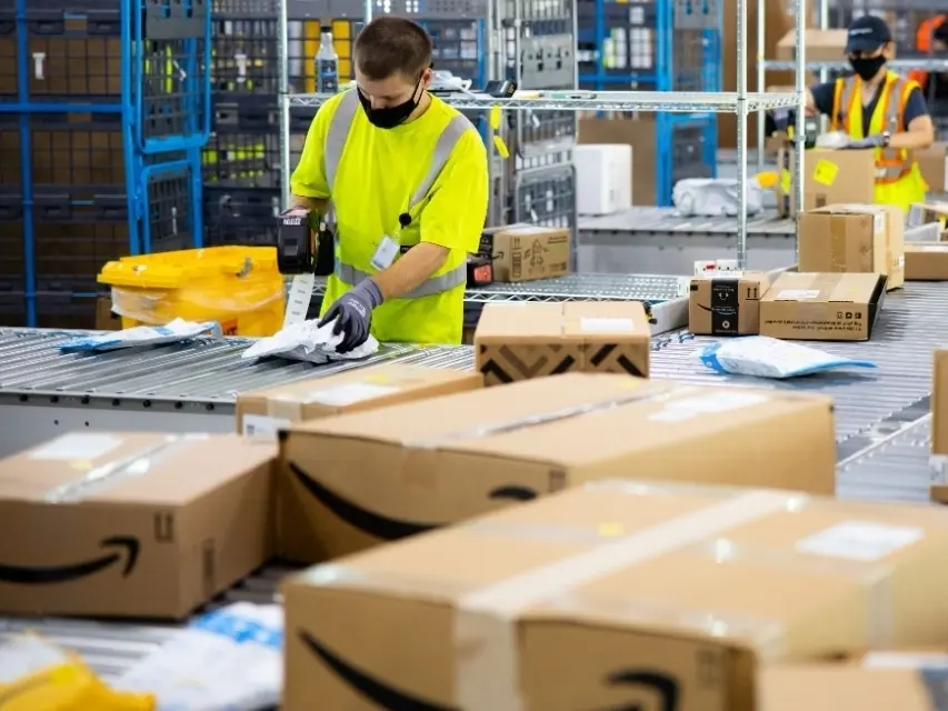 amazon employees labeling packages in warehouse 